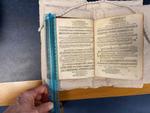 A hand using a ruler to measure the size of a page in butlers book